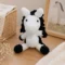 Doudou cheval au crochet artisanal blanc et noir présenté dans une chambre de bébé