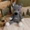 Doudou loup au crochet artisanal dans une chambre d’enfant Doudou loup au crochet artisanal gris installé dans une chambre d’enfant sur une couverture douce