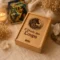 Coffret en bois gravé de l'Oracle des Loups présenté dans une ambiance spirituelle chaleureuse avec bougie, cristaux et fleurs séchées.