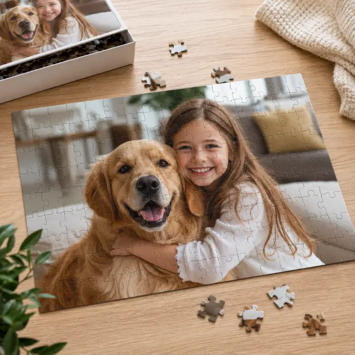 Puzzle photo personnalisé – Enfant et chien Puzzle photo personnalisé représentant une enfant souriante avec son chien golden retriever sur une table en bois.